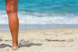 Schöne Beine am Strand von Sardinien.